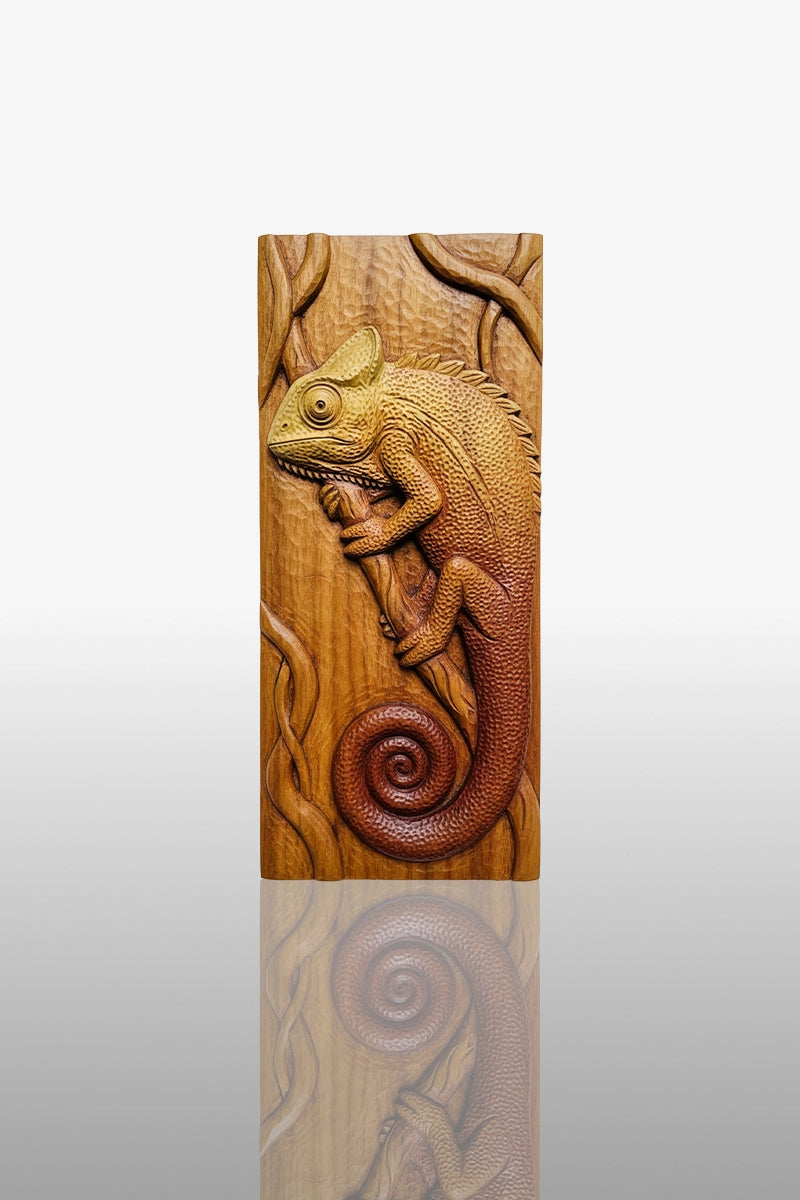 Hand-carved chameleon relief in camphor wood with curled tail and vine details, 11 x 26 inches