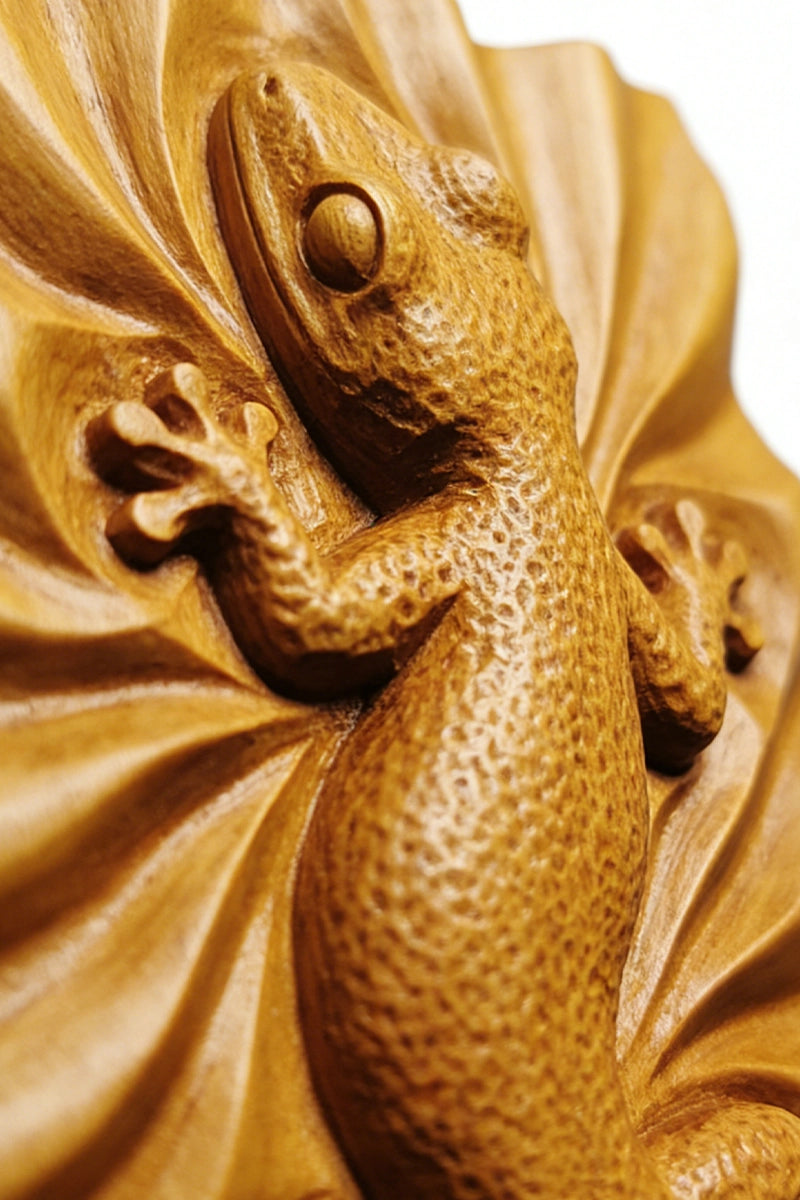 Gecko wood carving detail showing stippled skin texture and splayed toes
