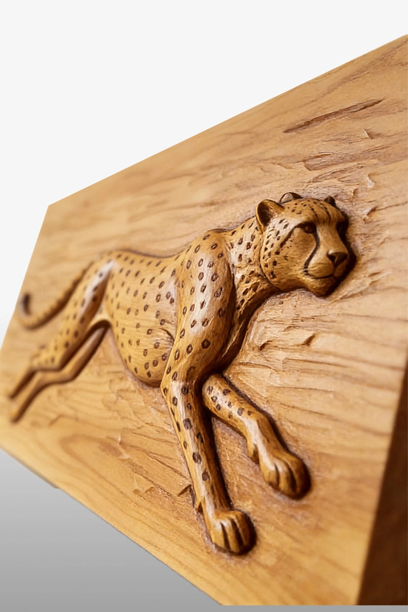 Cheetah wood carving detail showing spot pattern and elongated limbs