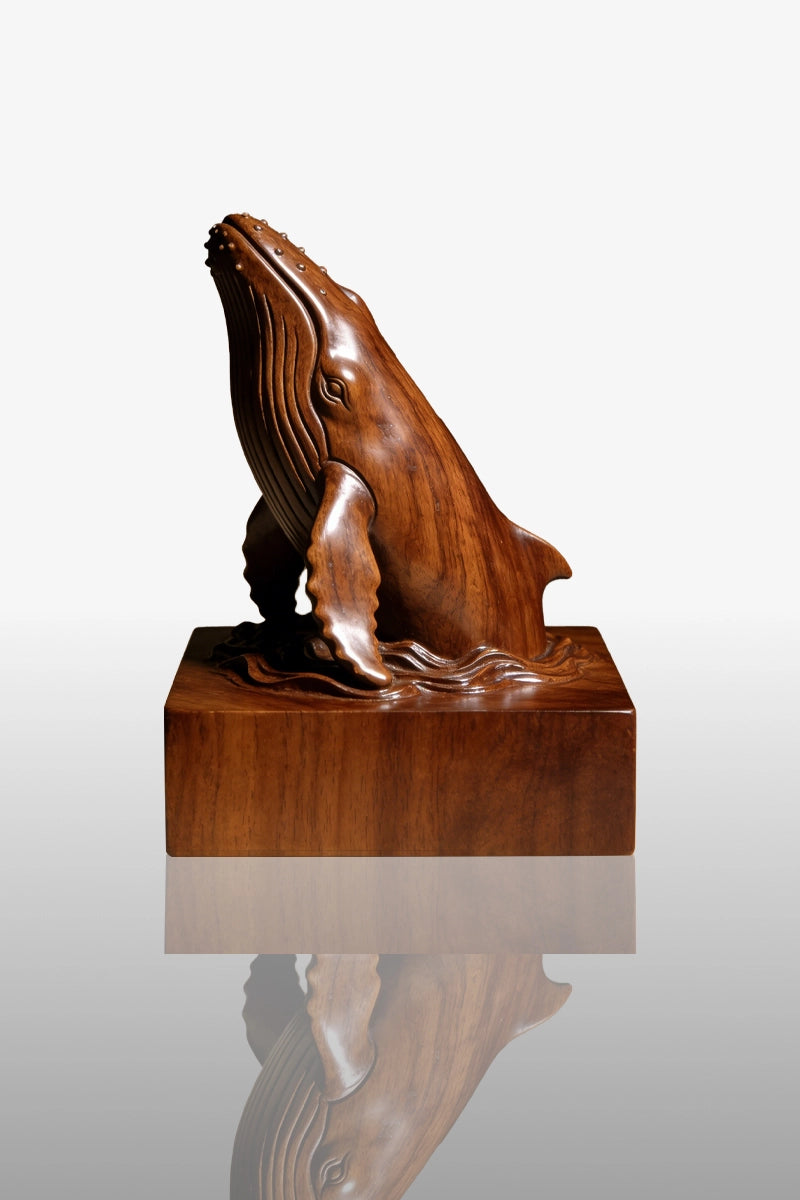 Hand-carved breaching humpback whale sculpture in camphor wood on wave base
