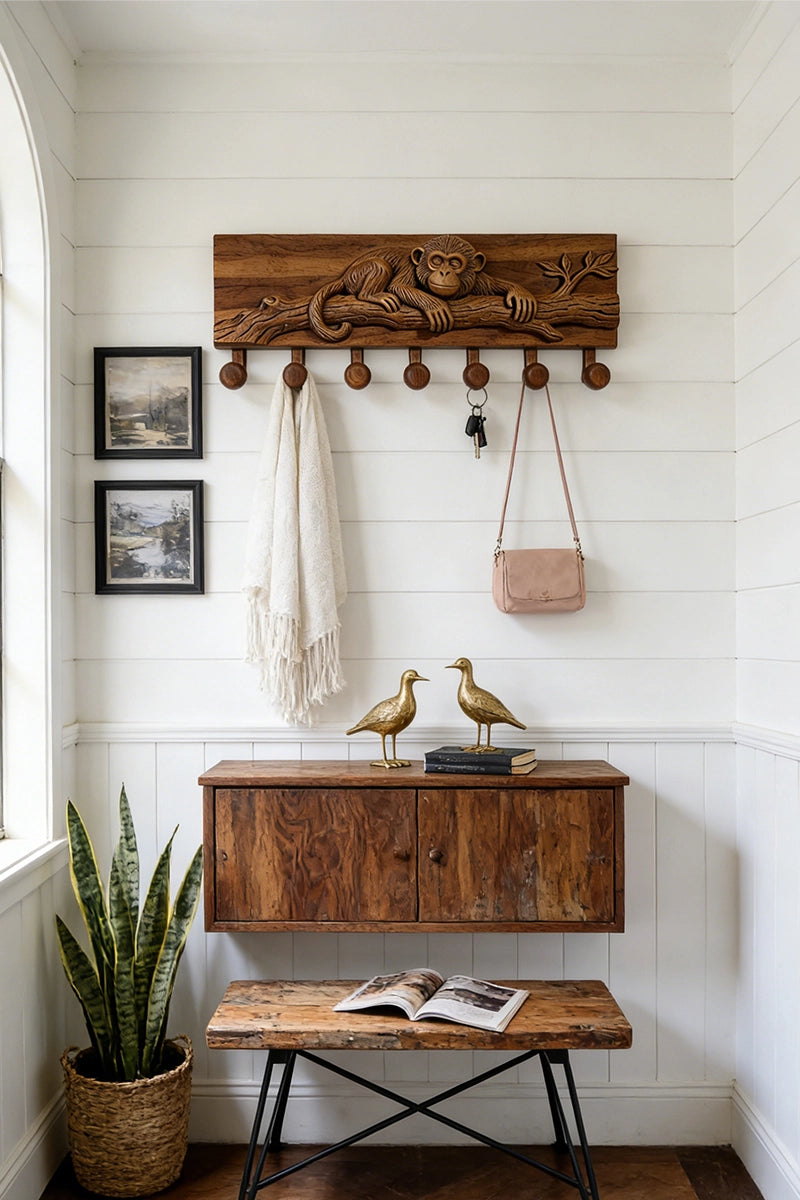 Monkey wood carved coat rack mounted in entryway with hanging coats